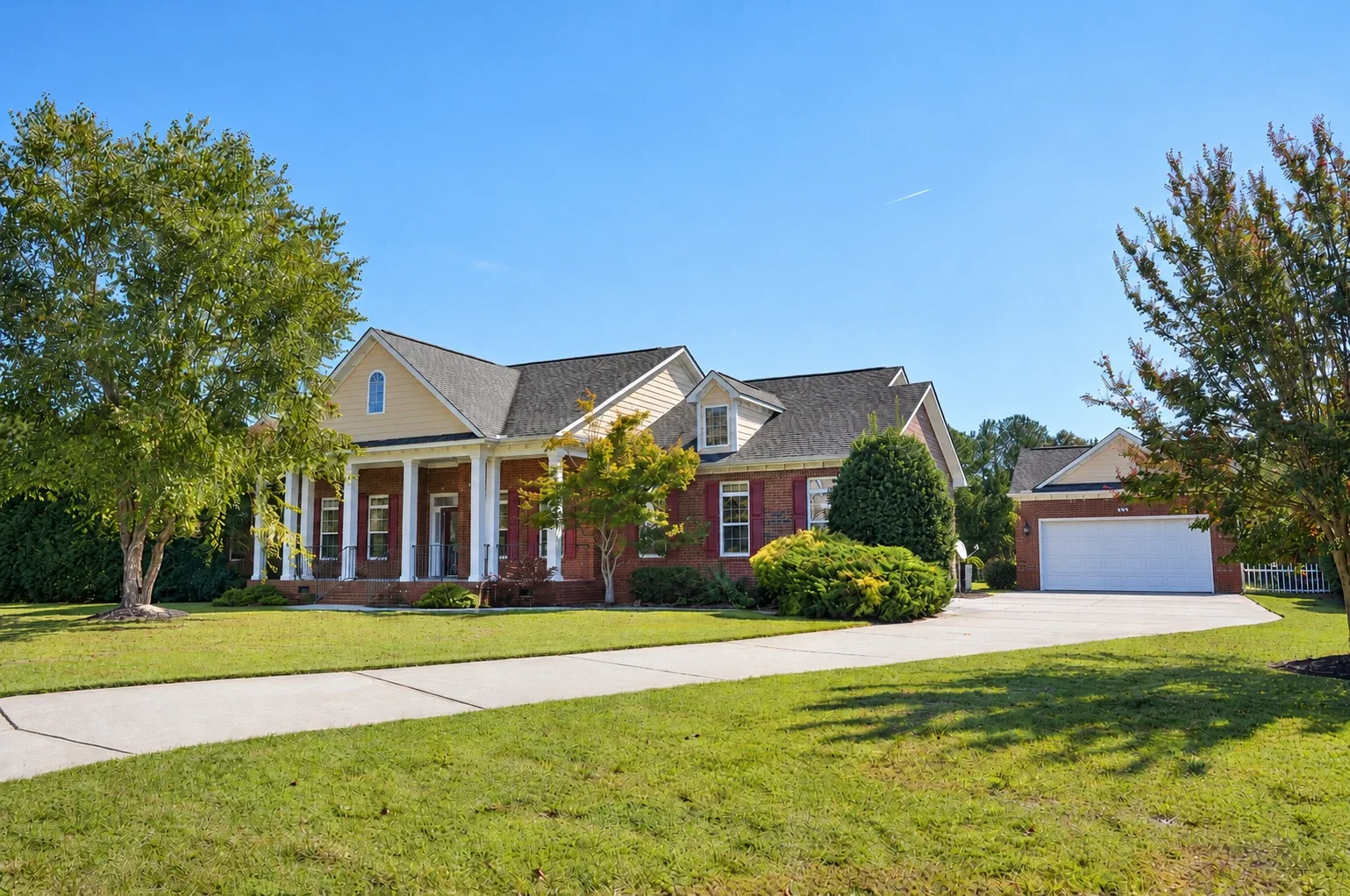 Brick home with a columned front porch, photographed in daylight