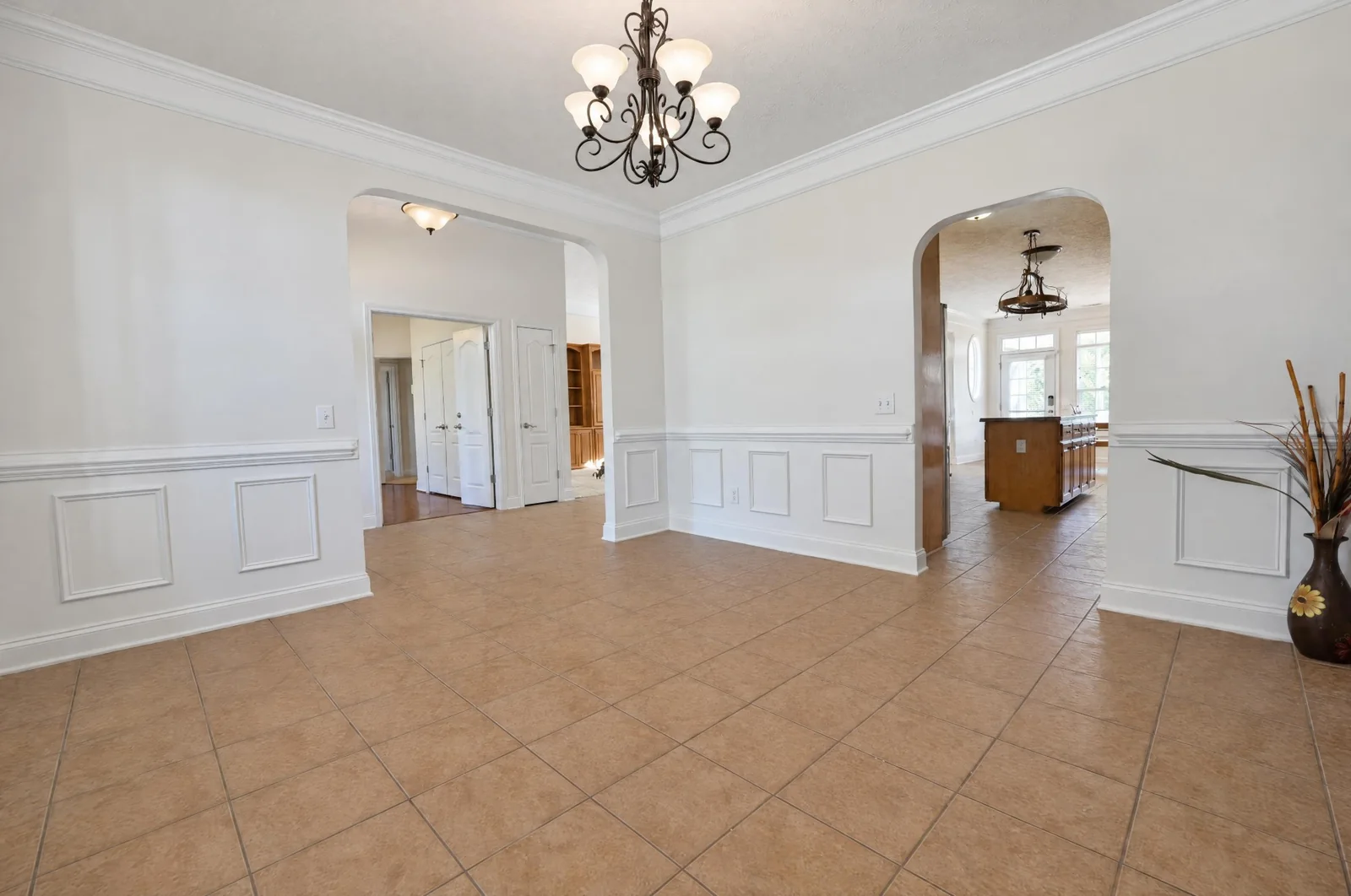 Formal dining room with wainscoting and arched doorways