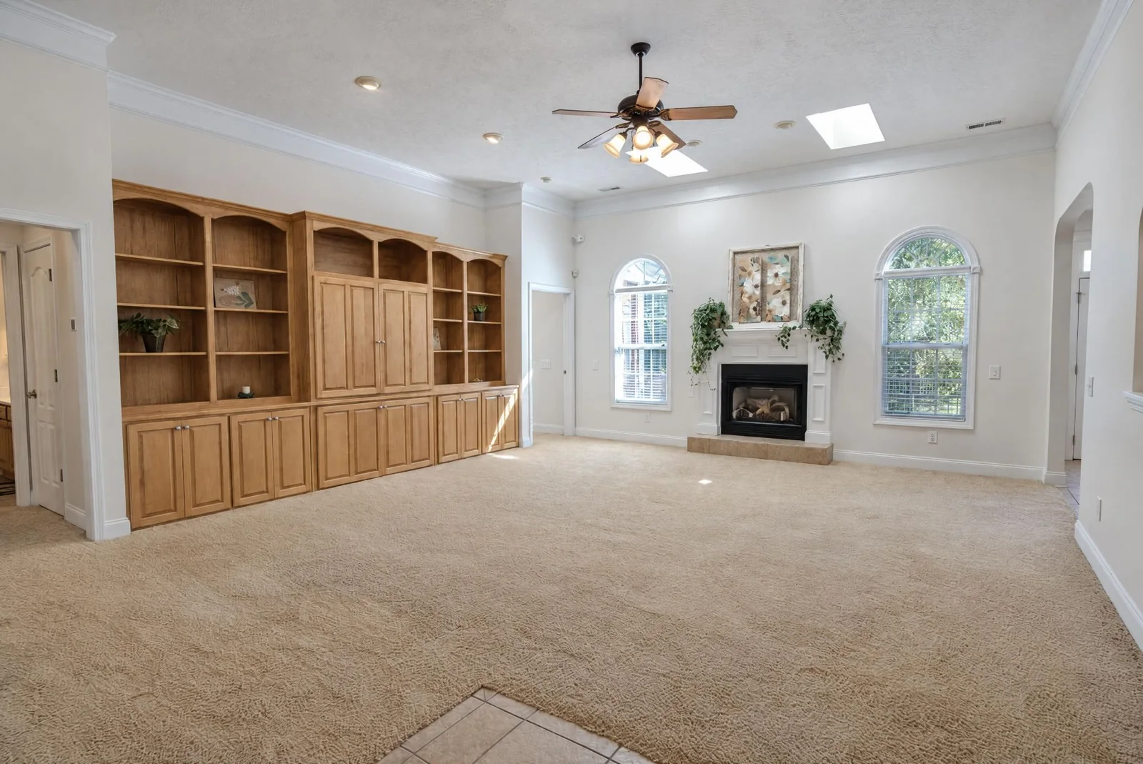 Living room with built-in shelving, skylights and a gas fireplace