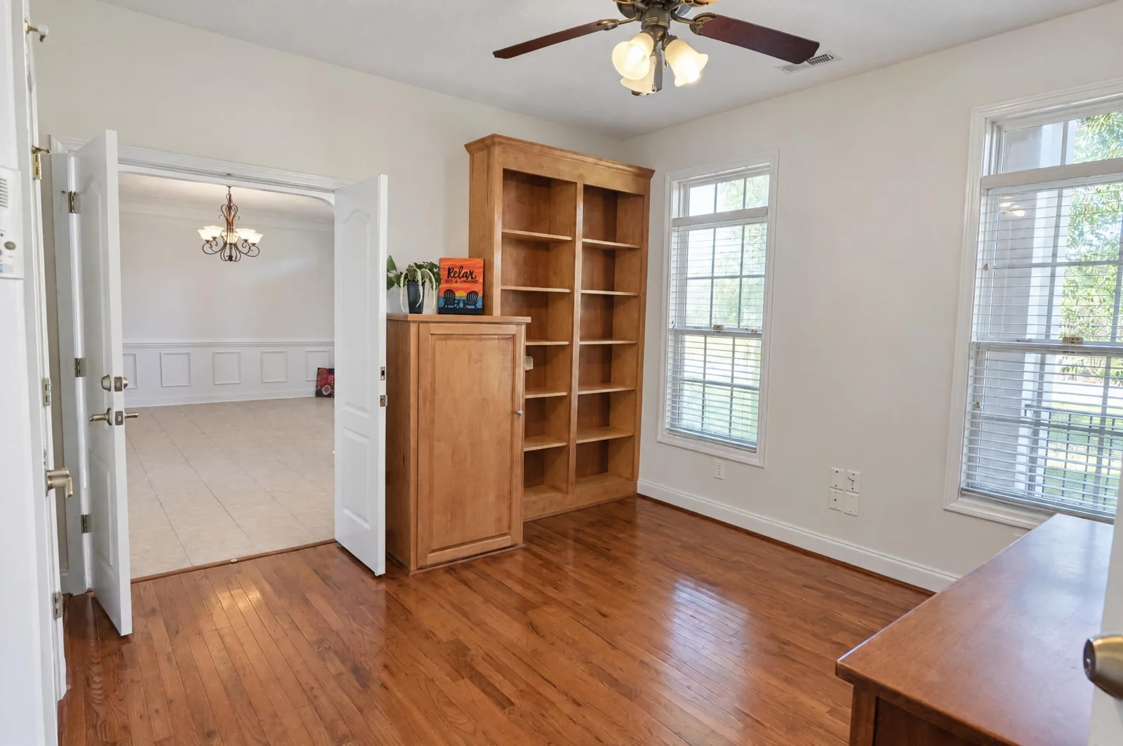 Home office with hardwood floors, built-in bookcase and French doors